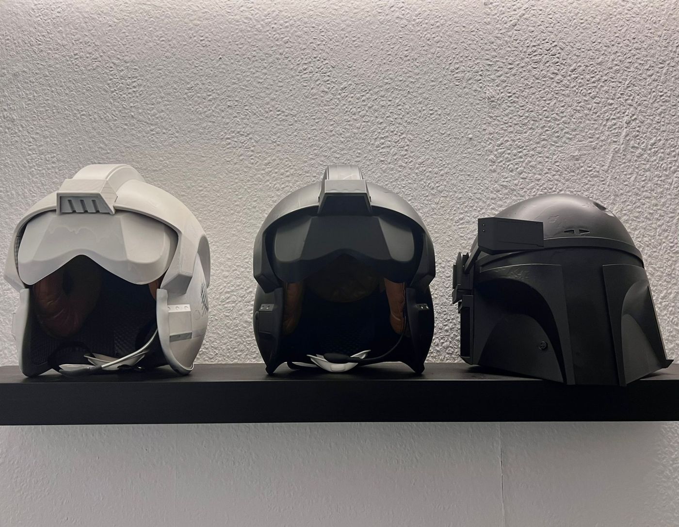 Drei Helme als Deko auf einem Regal im Studio