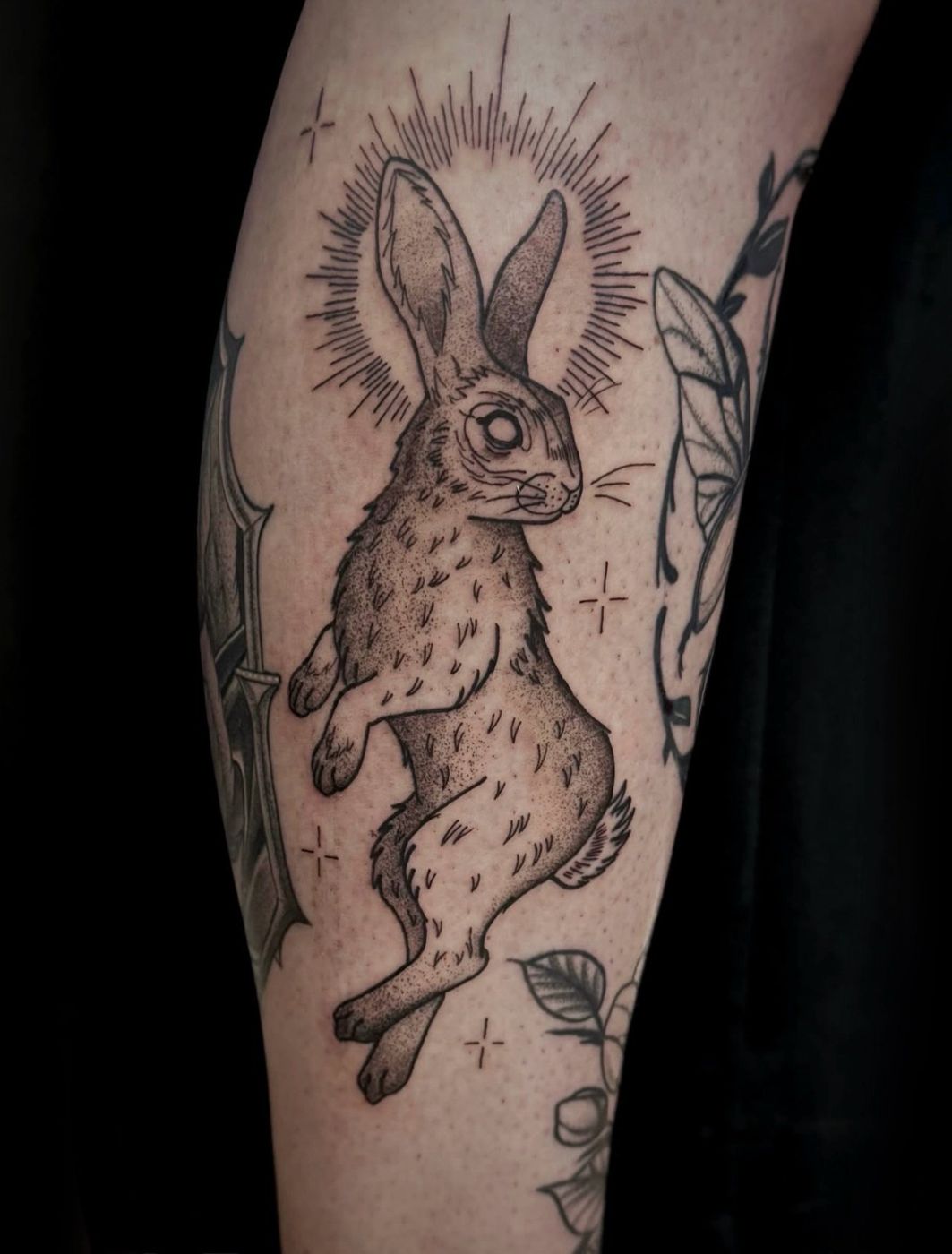 Tattoo von Dani: Hase mit Strahlenkranz und Blättern